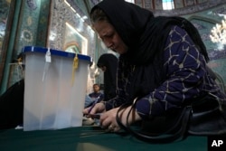 A woman fills out her ballot during the Iranian presidential election at a polling station in Tehran on June 28, 2024. (Vahid Salemi/AP)