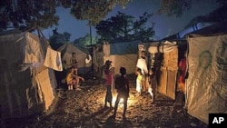 Earthquake survivors gather around a bonfire at a makeshift camp in Port-au-Prince, Haiti, where Tropical Storm Tomas might be headed, 01 Nov 2010