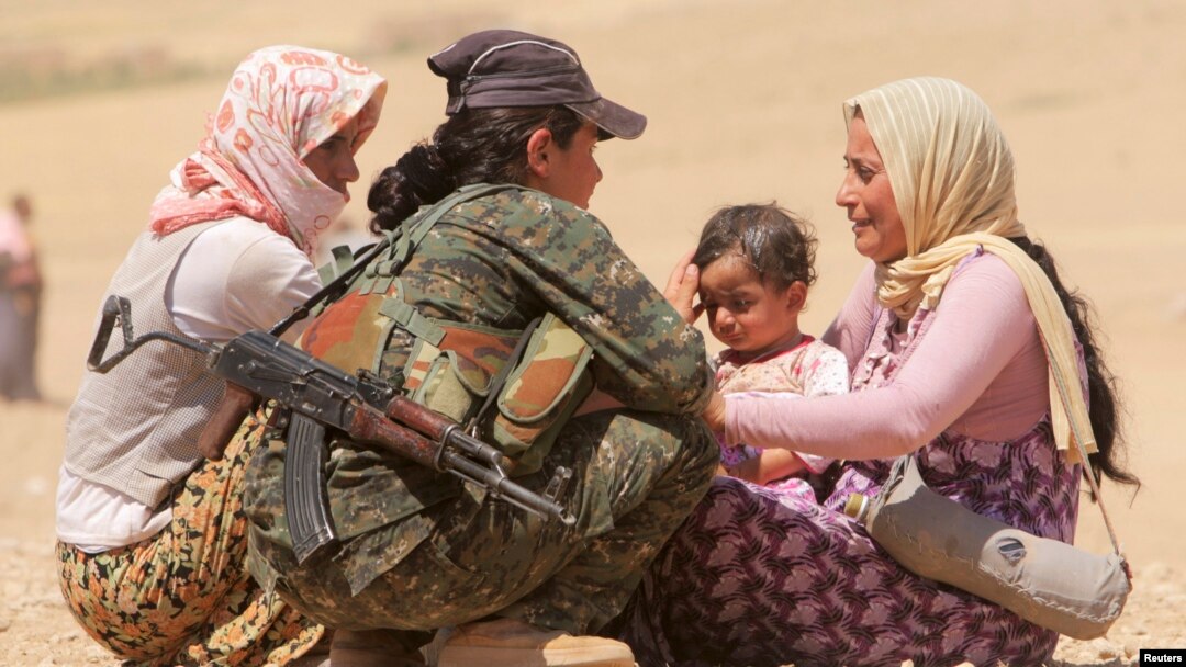 Kurd askari iroqlik qochqinlar bilan gaplashayapti. 