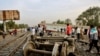 People gather at the site where a passenger train derailed injuring at least 100 people, near Banha, Qalyubia province, Egypt, April 18, 2021.