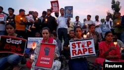 FILE - People participate in a candlelight vigil as they protest the rapes of an 8-year-old girl in Kathua near Jammu, and a teenager in Unnao, Uttar Pradesh state, in Bengaluru, India, April 13, 2018.