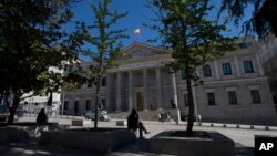 A man sits outside the Spanish Parliament in Madrid, Spain, May 3, 2016. Spain's King has signed a decree Tuesday dissolving parliament and calling elections for June 26 after deputies failed to agree on a new prime minister.