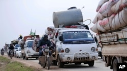 FILE - Syrians flee the advance of government forces towards the Turkish border, in Idlib province, Syria.