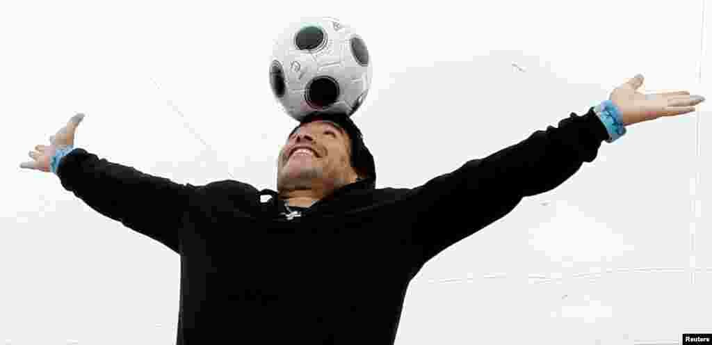 O ex-astro do futebol Diego Maradona equilibra uma bola de futebol na cabeça durante uma sessão fotográfica para &quot;Maradona by Kusturica&quot;, do realizador sérvio Emir Kusturica, no 61&ordm; Festival de Cinema de Cannes, 20 de maio de 2008