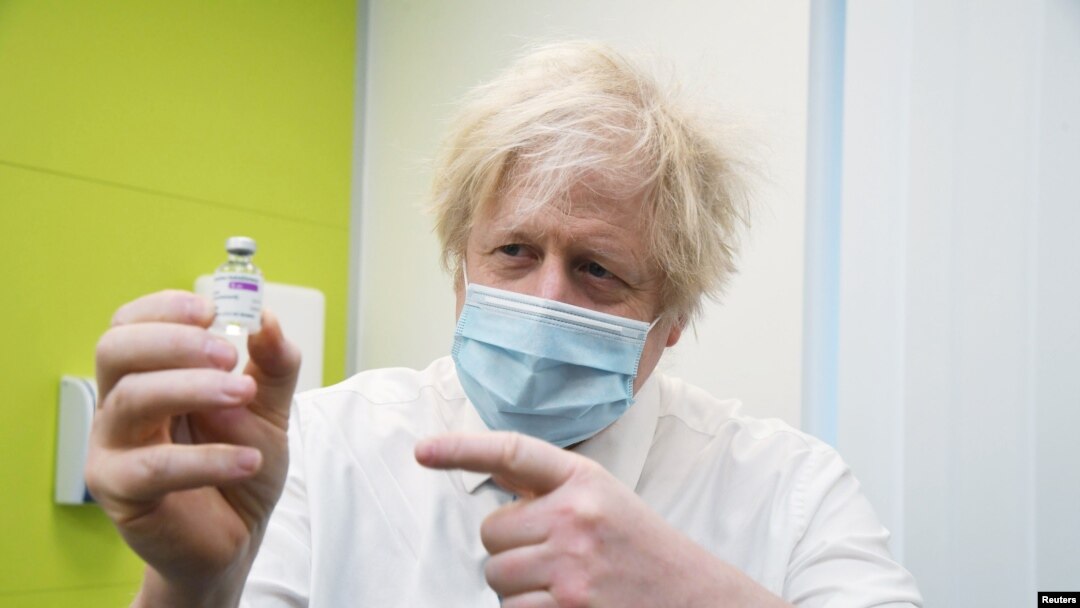 Perdana Menteri Inggris Boris Johnson menunjukkan ampul vaksin virus corona buatan Astra Zeneca saat mengunjungi pusat vaksinasi COVID-19 di Orpington, di Selatan-Timur London, Britain, Sein, 15 Februari 2021.