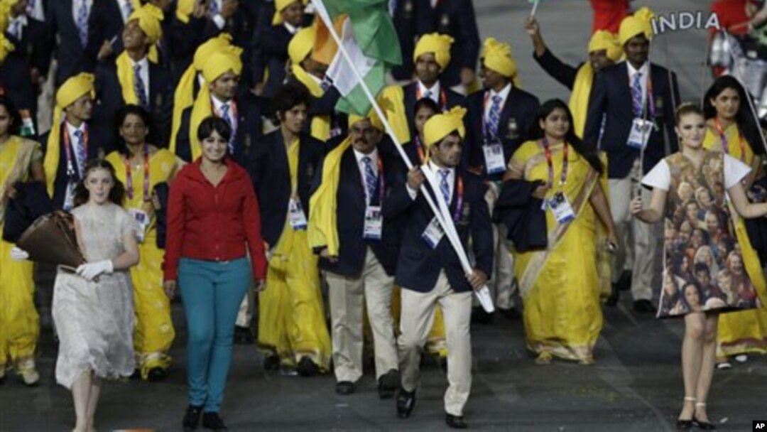 Seorang perempuan tak dikenal (baju merah) ikut bergabung bersama kontingen India di samping pembawa bendera Sushil Kumar, dalam pembukaan olimpiade di London (27/7). 