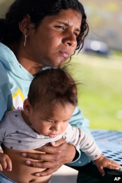 Ivanni Herrera holds her baby, Milan Guzman, during an interview in a park on May 18, 2024, in Aurora, Colorado.