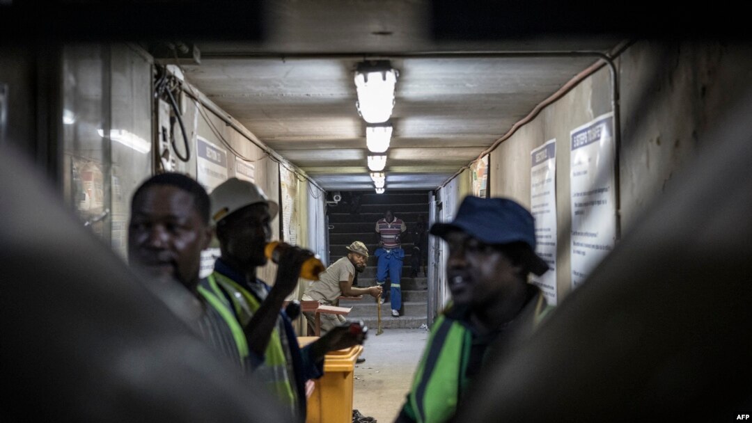 Mineworkers gather inside the entrance to the Gold One Modder East operation mineshaft in Springs, on October 24, 2023.