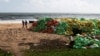 Ludi hodaju pored hrpa plastike koju je okean izbacio na obalu nakon požara na kontejnerskom teretnjaku MV Eks-pres perl u Kapungodi, u predgrađu Kolumba, Šri Lanka, 11. juna 2021.