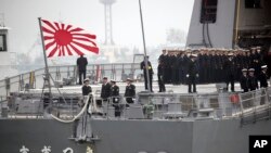 FILE - Sailors stand on deck of the Japanese destroyer Suzutsuki as it prepares to dock at a port in Qingdao in eastern China's Shandong Province, April 21, 2019.