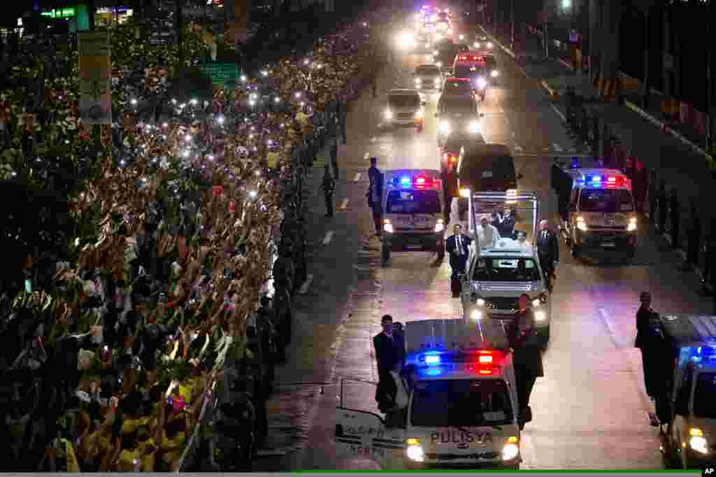 A huge crowd of Filipino faithful gather in excitement along Roxas Boulevard in Manila, Philippines, as they welcome the motorcade of Pope Francis.