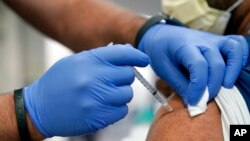 FILE - A person receives a Pfizer COVID-19 booster shot at Jackson Memorial Hospital, in Miami, Oct. 5, 2021. 