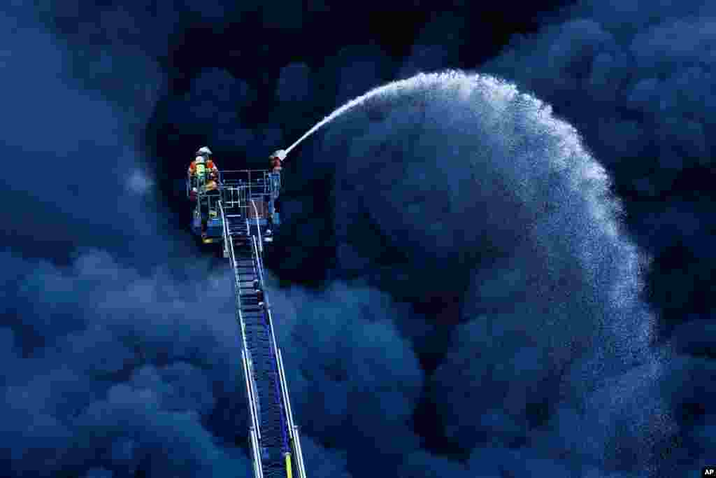 Firefighters extinguish a fire at a plastic factory in Ladenburg, Germany.