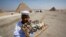 A child vendor waits for tourists to sell them souvenirs at the Giza Pyramids, on the outskirts of Cairo, August 26, 2013.
