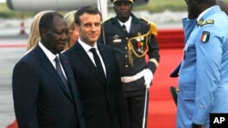 Le président ivoirien Alassane Ouattara (à g.) accueille son homologue français Emmanuel Macron à son arrivée à Abidjan, Côte d'Ivoire, le vendredi 20 décembre 2019. (AP Photo/Diomande Ble Blonde)