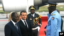 FILE - French President Emmanuel Macron is welcomed by President Alassane Ouattara upon arrival in Abidjan, Ivory Coast, Dec. 20, 2019. 