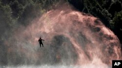 A soldier is lowered from a helicopter to practice rescuing a person in the water during a joint rescue operation in the U.S.-China Disaster Management Exchange (DME) in Kunming, China's Yunnan Province, Friday, Nov. 18, 2016.