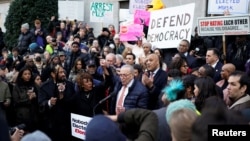 Senate Minority Leader Chuck Schumer speaks as U.S. Representative Maxine Waters stands next to him, while demonstrators rally outside the U.S. Treasury Department in Washington on Feb. 4, 2025. 