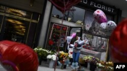 Una mujer sale de la floristería Caruso con un ramo de flores el día de San Valentín en Washington, DC.