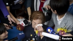 Former comfort woman Chen Lien-hua, center, wipes tears as she talks to media during a ceremony unveiling the nameplate of a museum dedicated to Taiwan's "comfort women" on International Women's Day, in Taipei, Taiwan, March 8, 2016. 