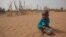FILE - А boy is seen eating dry couscous in the village of Goudoude Diobe, in the Matam region of northeastern Senegal.