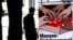 FILE - A man walks by a poster of the Swiss People's Party (SVP/UDC) argueing against the automatic right to citizenship, even for children born in Switzerland to foreign parents on Sept. 9, 2004.