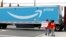 FILE - People hold a banner at the Amazon facility as members of a congressional delegation arrive to show their support for workers who will vote on whether to unionize, in Bessemer, Alabama, March 5, 2021. 
