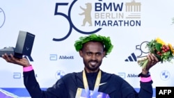 Ethiopia's Milkesa Mengesha celebrates on the podium after winning the 50th edition of the Berlin Marathon in Berlin, Sept. 29, 2024.