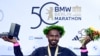 Pelari Ethiopia Milkesa Mengesha merayakan kemenangannya di podium setelah memenangkan Berlin Marathon ke-50 di Berlin, Jerman pada 29 September 2024. (Foto: AFP)