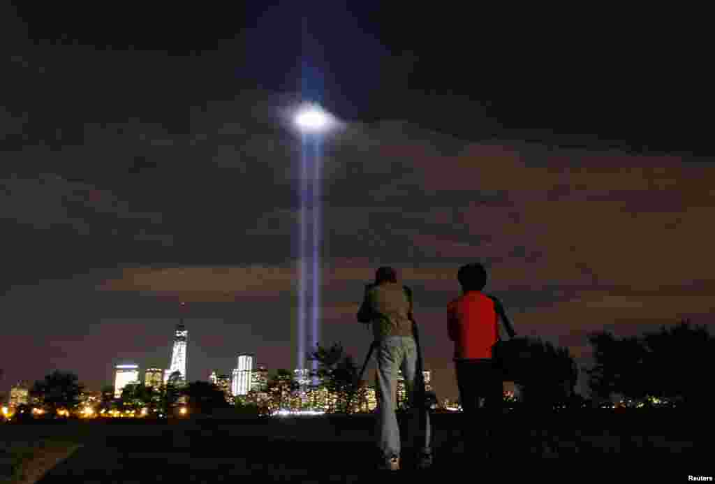 Sebuah Tribute Cahaya tahunan diuji di kota New York sementara seorang pria mengambil gambar dari Taman Liberty di Jersey City, negara bagian New Jersey.