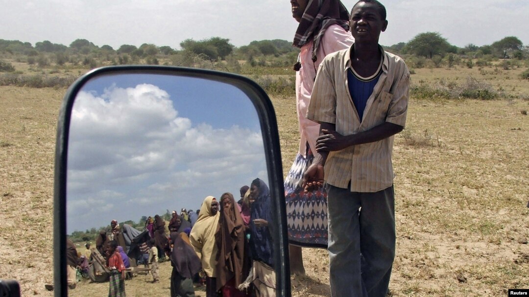 Penduduk Balad, utara ibukota Mogadishu, Somalia, (terlihat dari kaca spion) antri untuk mendapatkan pasokan makanan yang dibagikan oleh gerakan Al Shabaab (Foto: dok).