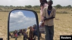 Penduduk Balad, utara ibukota Mogadishu, Somalia, (terlihat dari kaca spion) antri untuk mendapatkan pasokan makanan yang dibagikan oleh gerakan Al Shabaab (Foto: dok).