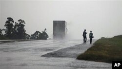 A couple walks along a highway as Hurricane Paula approaches the island in San Cristobal, Cuba, 13 Oct 2010