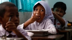 Para siswa di sebuah sekolah dasar di Jakarta menyantap makanan yang dibagikan dalam program Makan Bergizi Gratis (MBG) pada 6 Januari 2025. (Foto: Reuters/Willy Kurniawan)