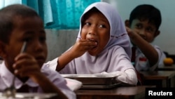 Para siswa di sebuah sekolah dasar di Jakarta menyantap makanan yang dibagikan dalam program Makan Bergizi Gratis (MBG) pada 6 Januari 2025. (Willy Kurniawan/Foto: Reuters)