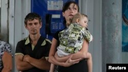 Local residents wait for a bus as they try flee fighting in the eastern Ukrainian city of Slovyansk June 10, 2014.