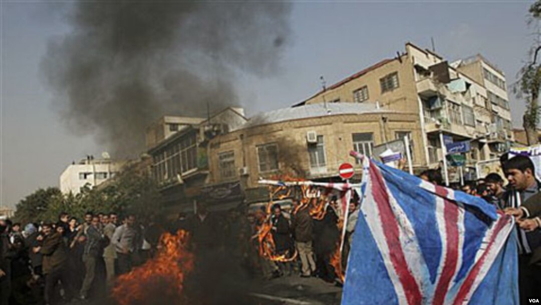 Para demonstran di Teheran membakar bendera Inggris dalam protes di depan Kedutaan Inggris di Teheran, Kamis 4 November 2010.