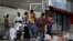 FILE - People search through the garbage on a street in Caracas, Venezuela, Nov. 30, 2016. As the economy suffers, some Venezuelans are forced to forage for food.