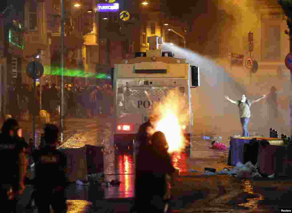 Riot police fire tear gas and a water cannon at Taksim Square in Istanbul, June 15, 2013. 