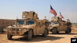 FILE - U.S. forces take up positions on the outskirts of the Syrian town, Manbij, a flashpoint between Turkish troops and allied Syrian fighters and U.S.-backed Kurdish fighters, March 7, 2017.