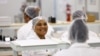 FILE - Women interact at their solar panel factory called Ener-G-Africa, where they produce high-quality solar panels made by an all-female team, in Cape Town, South Africa, Feb. 9, 2023.