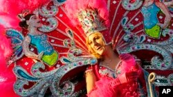 A maiden from the royal court of the Krewe of Endymion Mardi Gras parade smiles towards revelers in New Orleans, Feb. 25, 2017.