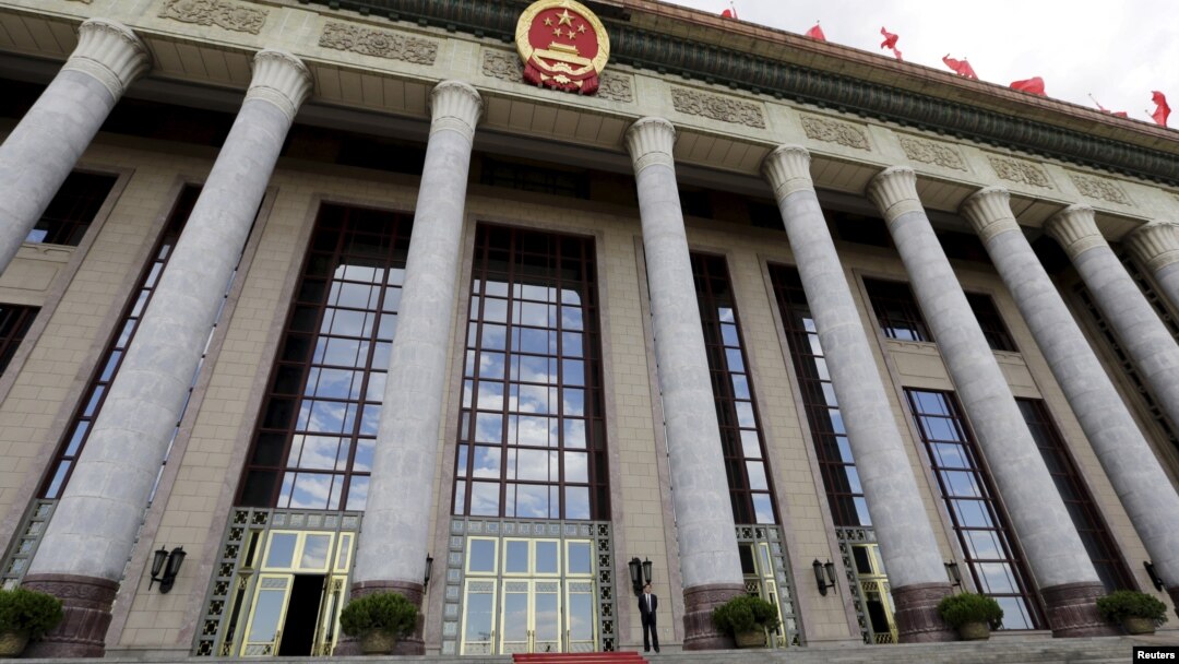 FILE - An officer stands outside the Great Hall of the People, the venue of National People's Congress, China's parliament, in Beijing.