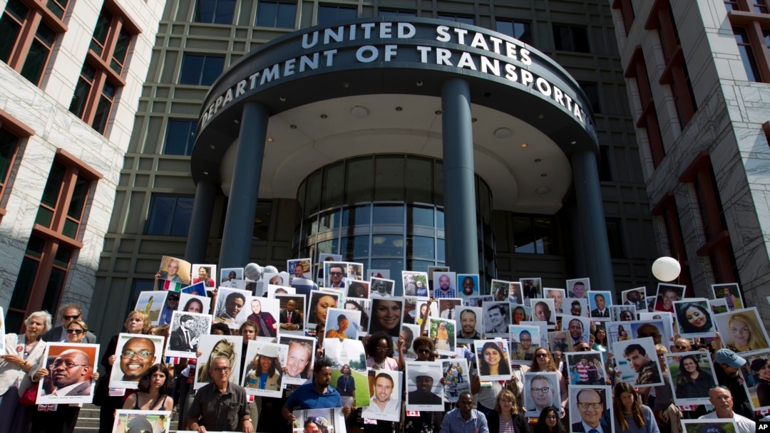 FILE - Demonstrators hold pictures of plane crash victims during a vigil, Sept. 10, 2019, in Washington, on the six-month anniversary of the crash of a Boeing 737 Max 8 that killed 157 people in Ethiopia, March 10, 2019.