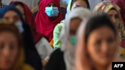 FILE - Afghan women take part in a gathering at a hall in Kabul on August 2, 2021 against the claimed human rights violations on women by the Taliban regime in Afghanistan.