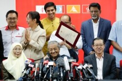 FILE - Malaysia Prime Minister Mahathir Mohamad, center, shows document of Registration of Pakatan Harapan "Alliance of Hope" during a press conference in Petaling Jaya, Malaysia, May 17, 2018.