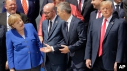 (L-R) German Chancellor Angela Merkel, Belgian Prime Minister Charles Michel, NATO Secretary-General Jens Stoltenberg and U.S. President Donald Trump, watch a fly-by during a summit of heads of state and government at NATO headquarters in Brussels, July 11, 2018.