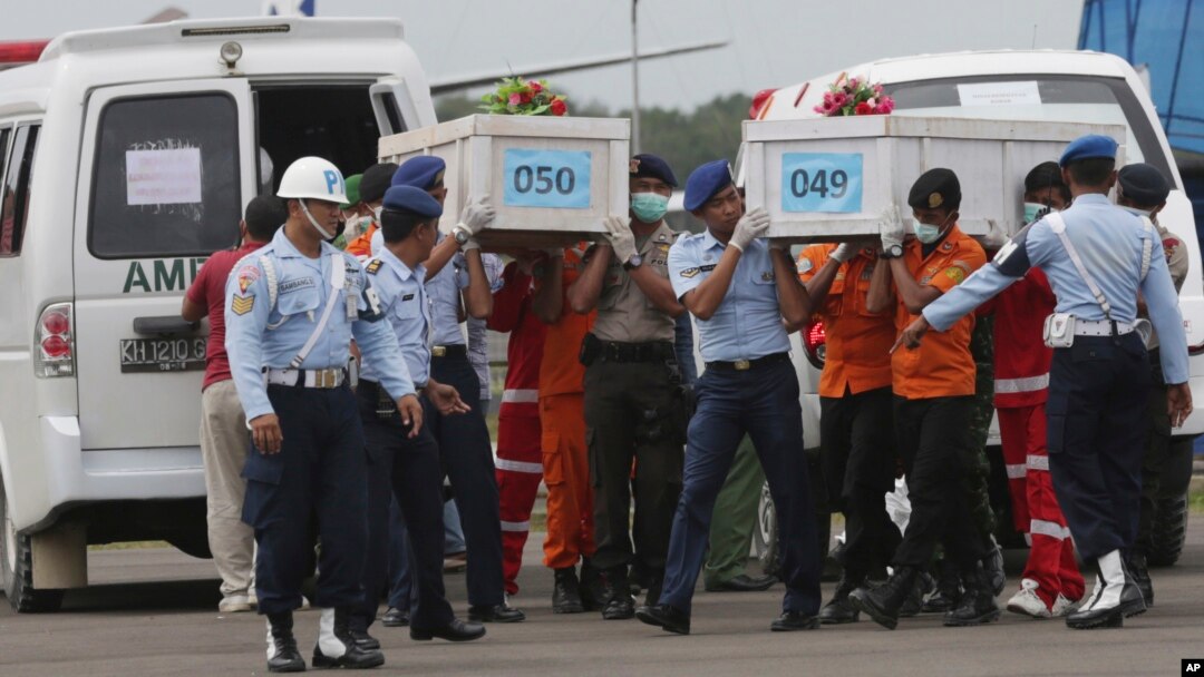 Các thành viên của Cơ quan Tìm kiếm cứu hộ quốc gia khiêng các quan tài chứa thi thể của các nạn nhân trên chuyến bay AirAsia 8501 tại sân bay Surabaya ở Pangkalan Bun.
