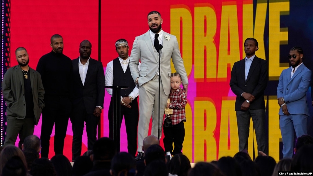 Friends and family look on as Drake accepts the artist of the decade award while he holds his son Adonis Graham at the Billboard Music Awards on May 23, 2021, at the Microsoft Theater in Los Angeles.