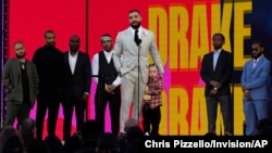 Friends and family look on as Drake accepts the artist of the decade award while he holds his son Adonis Graham at the Billboard Music Awards on May 23, 2021, at the Microsoft Theater in Los Angeles.